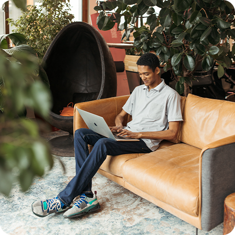 Young man sitting on couch with laptop